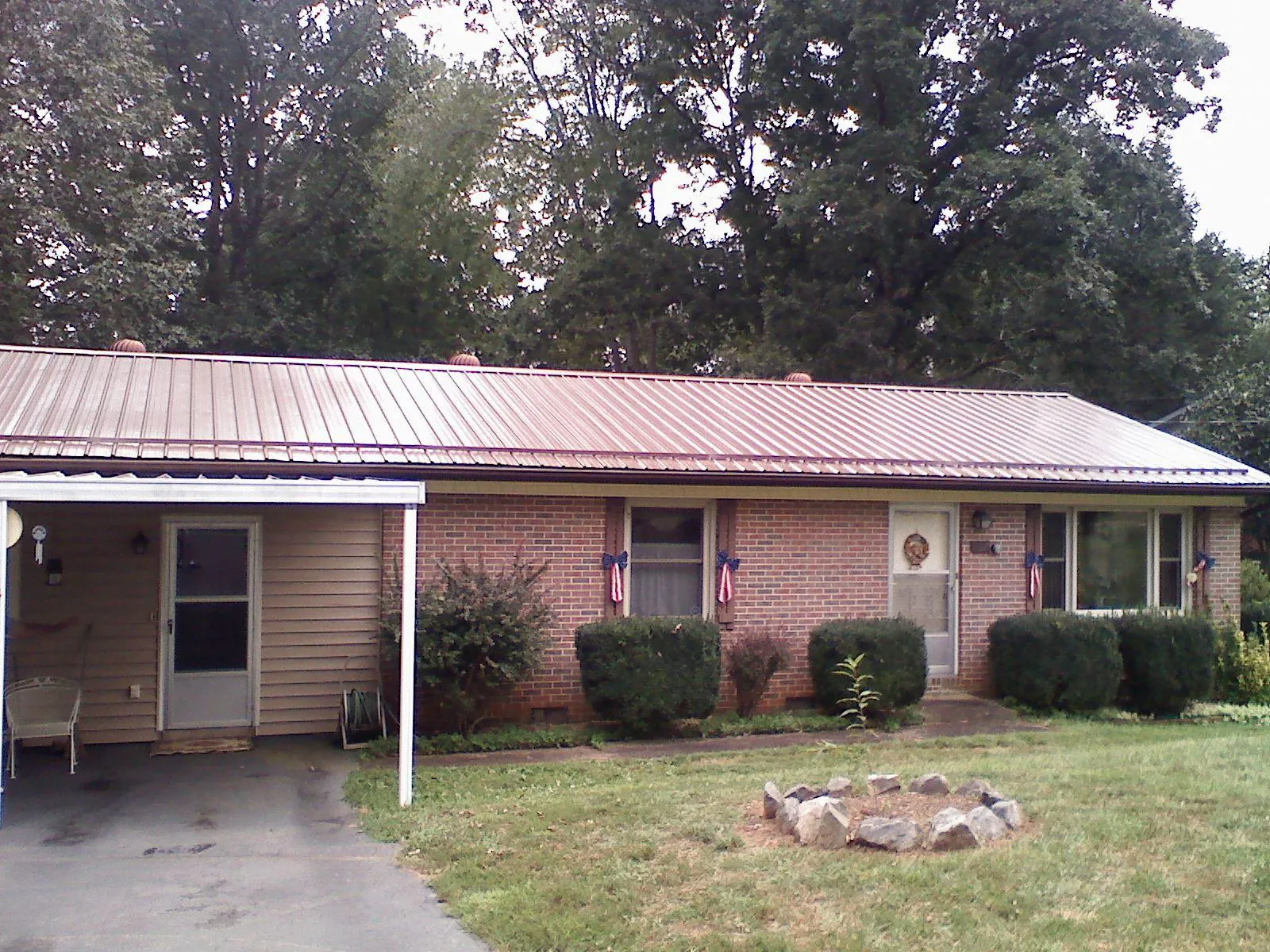 Bronze metal roof and carport on a brick ranch home — Roof Repair work by our crew in Cedar Creek